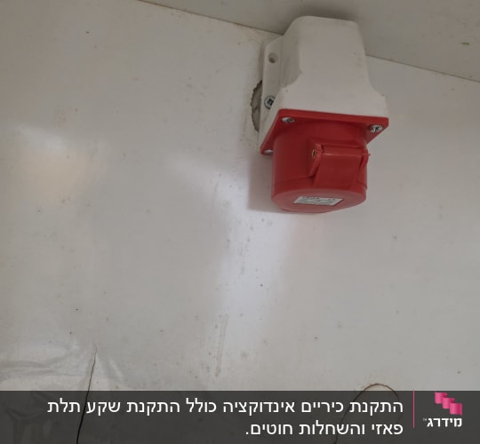 שקע חשמלי אדום על קיר לבן